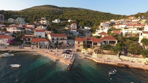 A coastal town with buildings, a beach, and boats. - Holiday apartment only 50 m from the sea (Komarna)
