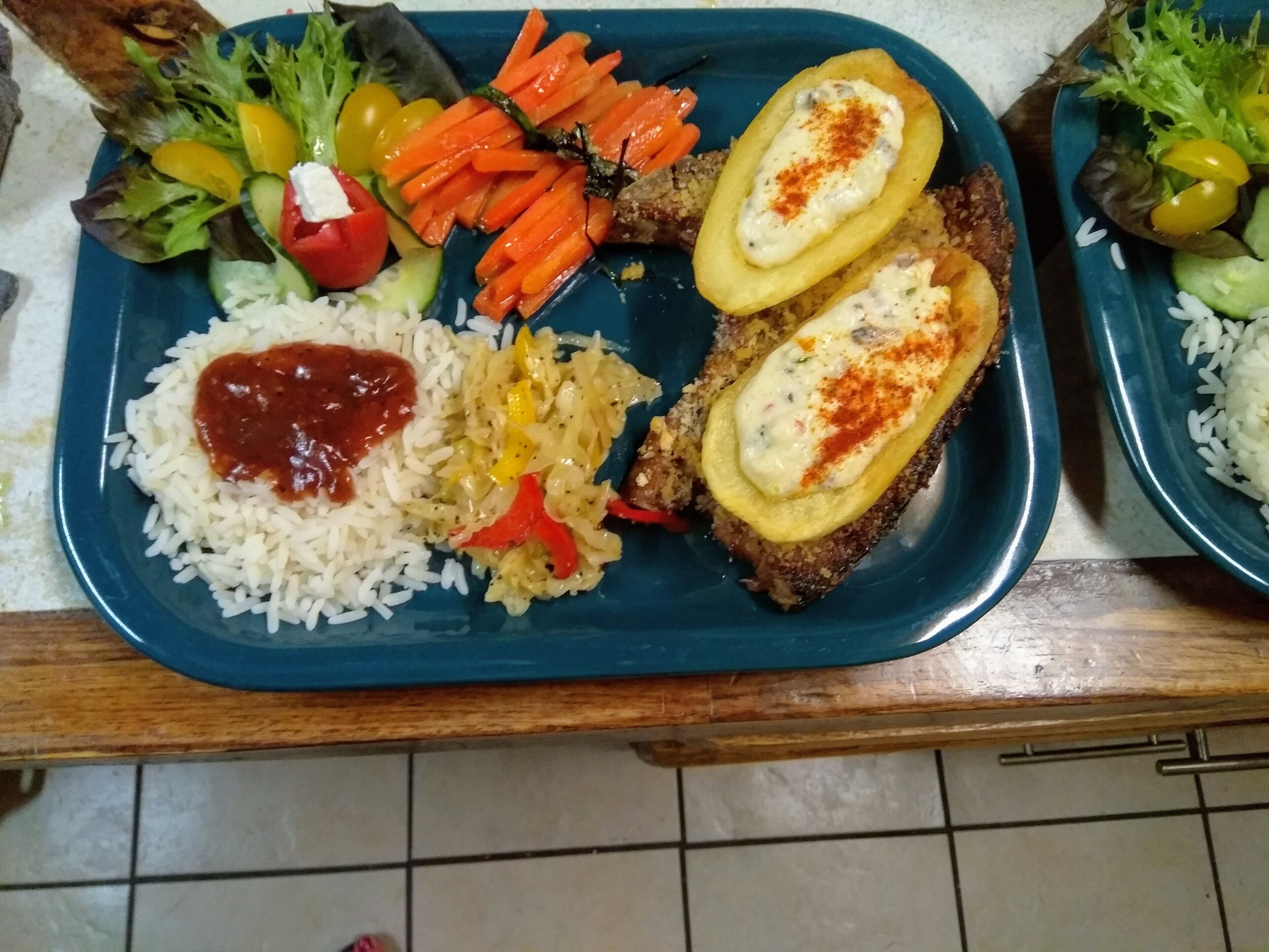 Un piatto con riso, verdure e una fetta di pane farcita.