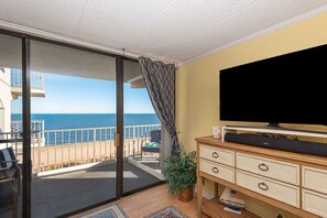 Enjoy ocean views from the balcony, featuring a flat-screen TV and comfortable seating area.