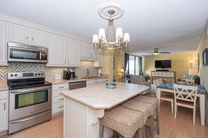 Cozy kitchen with a central island, dining area, and mounted TV.