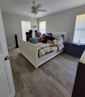 Relax in this serene bedroom with a comfortable bed, large window, and ceiling fan.