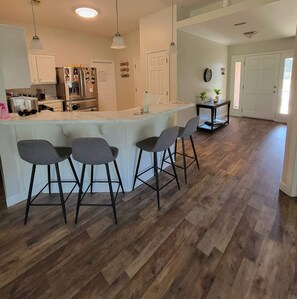 Enjoy meals in the kitchen with a central island and bar stools, an oven, and a dining area with a table and chairs.