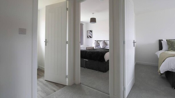 A bedroom with a bed, bedside table, and a nightstand. - Beautiful 4-bed House 15 Mins to Cardiff & Newport (Cardiff)