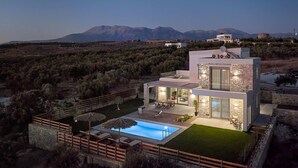 A modern two-story house with a swimming pool, outdoor furniture, and a view of mountains. - Alba Lilia (Πιτσίδια)