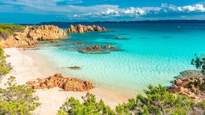 A coastal landscape with clear turquoise waters, rocky formations, and a sandy beach. - il Girasole (Golfo Aranci)