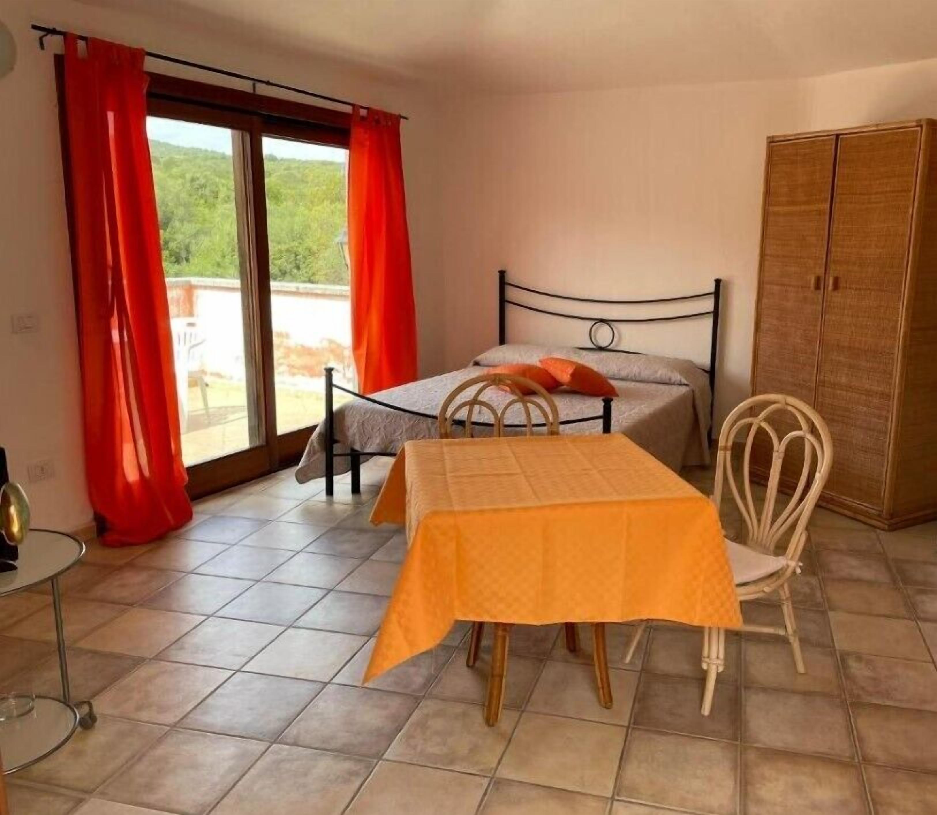 A room with a bed, a table, and a wardrobe.