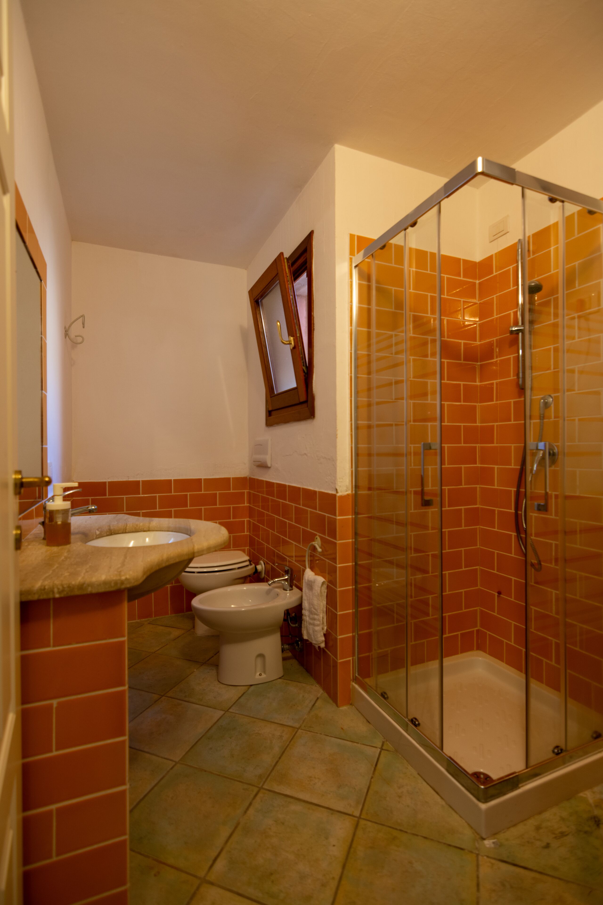 A bathroom with two sinks, a toilet, and a glass-enclosed shower.
