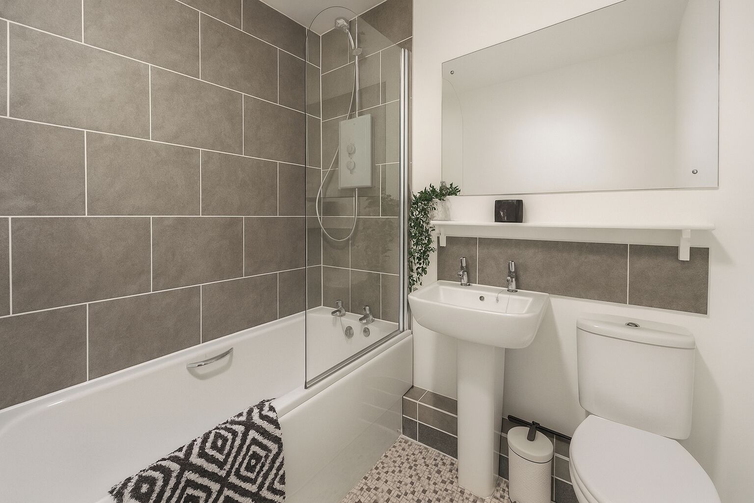 A modern bathroom with a bathtub, a sink, and a toilet.