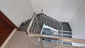 Eine Treppe mit Metallgeländern und Handlauf, die zu einer oberen Etage führt.