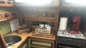 Une petite cuisine équipée comprenant un évier, un four à micro-ondes, un petit four et une machine à café.