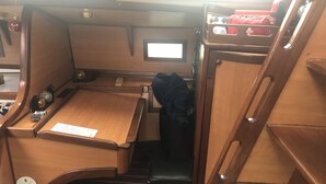 Un espace cuisine compact doté de plans de travail en bois, d’un évier et d’une fenêtre située au-dessus de l’évier.