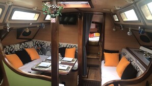 Un intérieur chaleureux comprenant un coin repas, des sièges et un petit espace clos avec un lit.