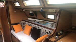 Un intérieur chaleureux avec un lit, des oreillers, une petite table et une fenêtre.