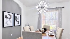 A dining area with a wooden table, six chairs, a chandelier, and two framed abstract paintings on the wall. - Lakeside 5bd Pool Hm Spa Gm Watersng-237ys 5 Bedroom Home by RedAwning (Davenport)