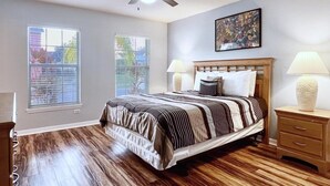 A bedroom with a bed, two bedside lamps, a ceiling fan, and two windows. - Terrific Value 4bd Pool Gm Spa Hm Sandy Ridge-640b 4 Bedroom Home by RedAwning (Davenport)
