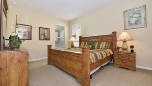A bedroom with a wooden bed, bedside tables, and a dresser. - Watersong Resort 6bd Pool Hm,2 Master Suites-956oc 6 Bedroom Home by RedAwning (Davenport)