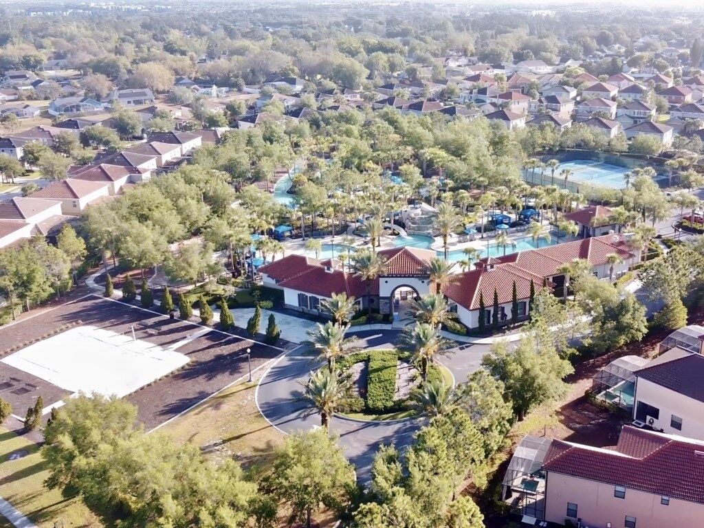 Eine Vogelperspektive eines Wohngebiets mit Häusern, einem Swimmingpool und einem großen Parkplatz.