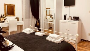 A hotel room with a bed, a desk, a wardrobe, a mirror, and a television. - La Dogaressa Guest House (Venice)