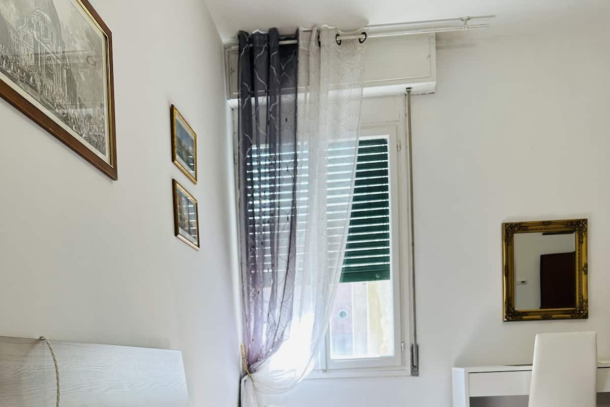A bedroom with a bed, a desk, and a chair.