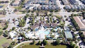 An aerial view of a residential area with a large swimming pool, a tennis court, and a small lake. - Gorgeous 4bd Th Pool Windsor At Westside-2018ww 4 Bedroom Home by RedAwning (Kissimmee)