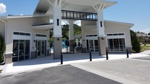 A modern building with a covered entrance, large glass doors, and a central atrium.