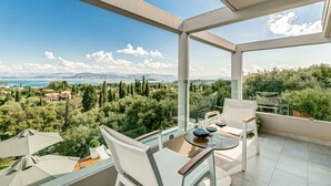 Ein geräumiger Balkon mit freiem Blick auf eine Berglandschaft und ein Gewässer.