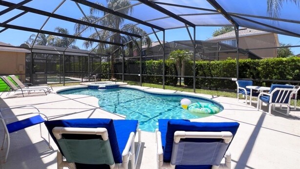 Une piscine couverte avec des chaises longues et un jacuzzi.
