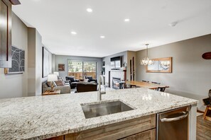 A modern kitchen with a granite countertop, stainless steel sink, and built-in appliances. - Remodeled 2br Condo, Private Balcony With Beaver Creek Mountain View, Steps From Avon Gondola 2 Bedroom Condo by RedAwning (Avon)