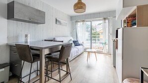 Een moderne keuken met een eethoek, een groot raam en uitzicht op buiten.