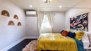 Un dormitorio con cama con dosel, una alfombra mullida y un cuadro en la pared.