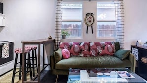 Una sala de estar con un sofá, una mesa de centro y una ventana con cortinas.