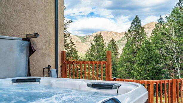 Un jacuzzi con terraza de madera y vistas a la montaña.