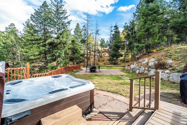 A hot tub on a wooden deck with a view of a forested area. - Mtn Getaway Near Pikes Peak | Hot Tub & Pool Table (Cascade-Chipita Park)