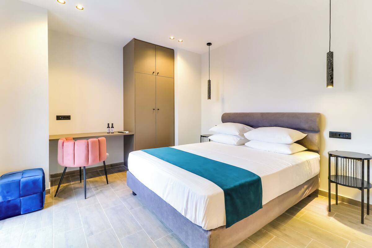 Ein modernes Hotelzimmer mit einem großen Bett, einem Schreibtisch und einem Stuhl.