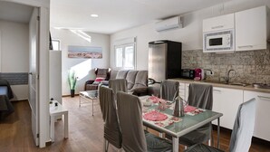 Une cuisine moderne équipée d’un four à micro-ondes, d’un grille-pain et d’un évier. Un coin repas avec une table et des chaises est également  à disposition.
