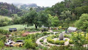A lush garden with a winding path, a gazebo, and a greenhouse. - The Barn Villa (Healdsburg)