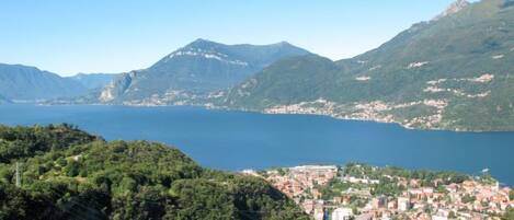 Une ville côtière située au pied de montagnes, avec une vaste étendue d’eau à proximité.
