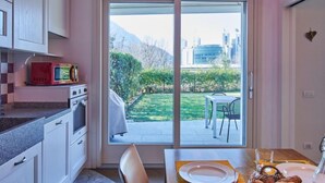 A modern kitchen with a sliding glass door leading to an outdoor dining area. - Promessi Sposi by Interhome (Lecco)