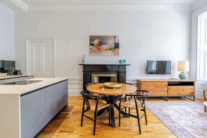 Une cuisine moderne avec un coin repas, une cheminée et un téléviseur à écran plat.