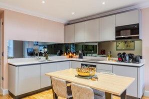 A modern kitchen with a central island, built-in appliances, and a dining area.