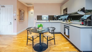 Una cucina moderna con un tavolo rotondo, sedie e una piccola isola con un lavello.