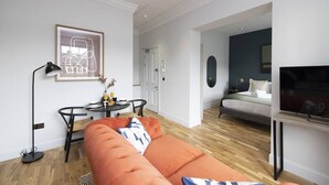 A modern living room with a sofa, a coffee table, and a framed artwork on the wall. - Wyvern Suite - City Centre 1 Bed Studio Apartment (Edinburgh)