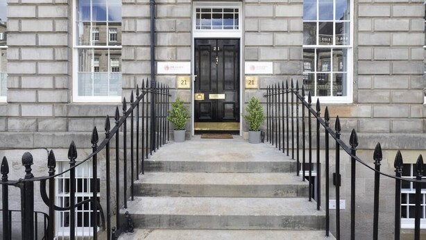 A building with a black door, numbered 21, flanked by two windows. - Wyvern Suite - City Centre 1 Bed Studio Apartment (Edinburgh)