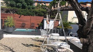 Una poltrona amaca sospesa a un albero, una piccola piscina e mobili da esterno.