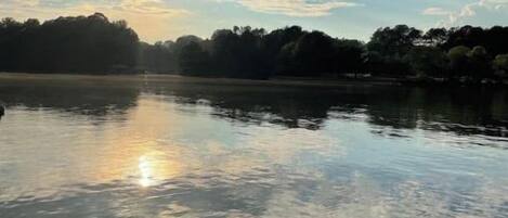 Un lago tranquilo que refleja claramente el cielo y los árboles.