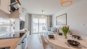 A modern kitchen with a dining area, a large window, and a view of the city.
