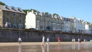 A waterfront promenade with stone buildings and a clear sky.