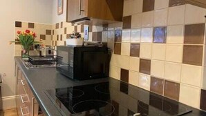A modern kitchen with a black stove, a microwave, and a coffee maker on the counter.