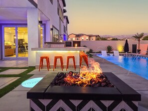 A poolside area with a fire feature, outdoor bar, and seating. - Ultimate Desert Getaway, Pool/Spa, 4k Game Room (Indio)
