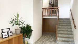 A staircase with a wooden handrail leading to a landing with a wooden door. - In the heart of Lake Como (Bellagio)